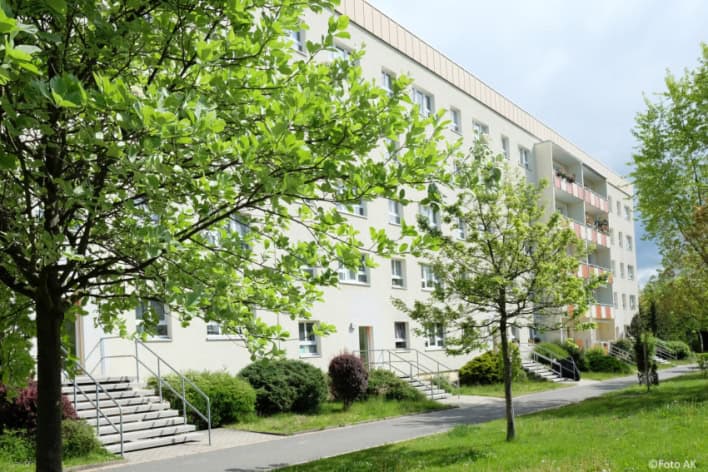 Auf dem Bild ist ein Wohnblock im Grünen zu sehen
