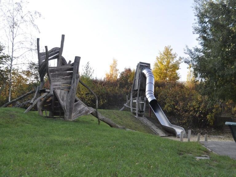 Auf dem Bild sind ein Klettergerüst und eine Rutsche zu sehen