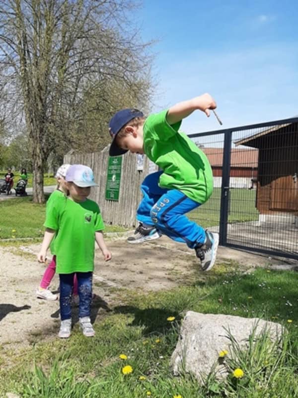 Auf dem Bild ist ein Junge zu sehen, der von einem Stein springt