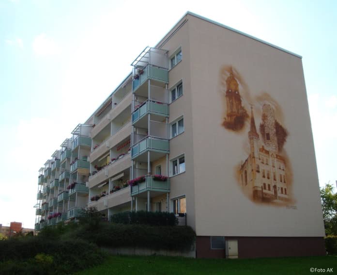 Auf dem Bild ist ein Wohnblock von außen zu sehen