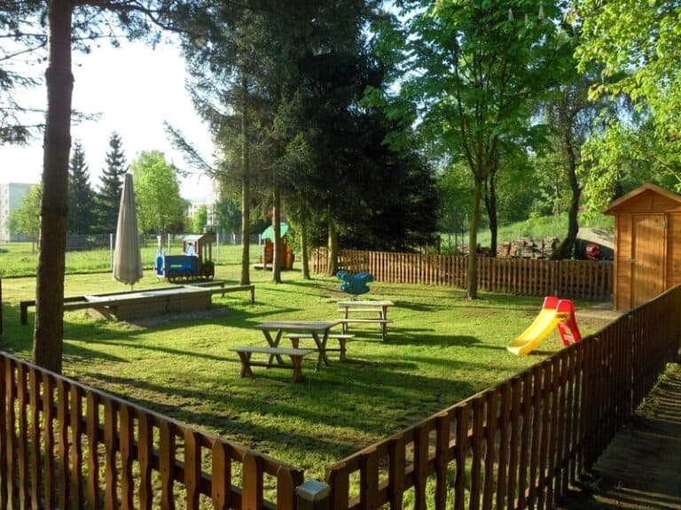 Auf dem Bild ist ein eingezäunter Spielbereich für Kinder zu sehen